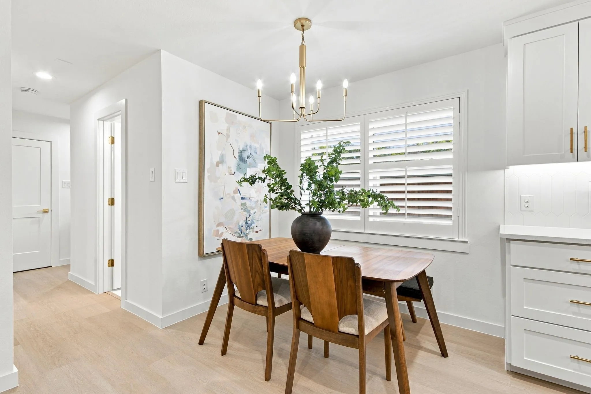 Wood-finish flooring, white walls, and a contemporary chandelier
