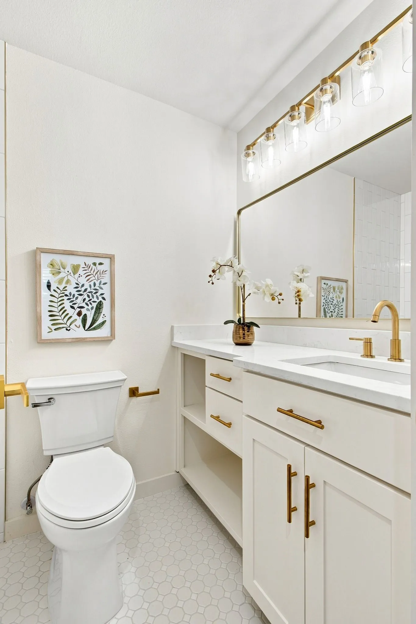 White vanity with a single integrated sink, gold-finish faucet, and coordinating hardware