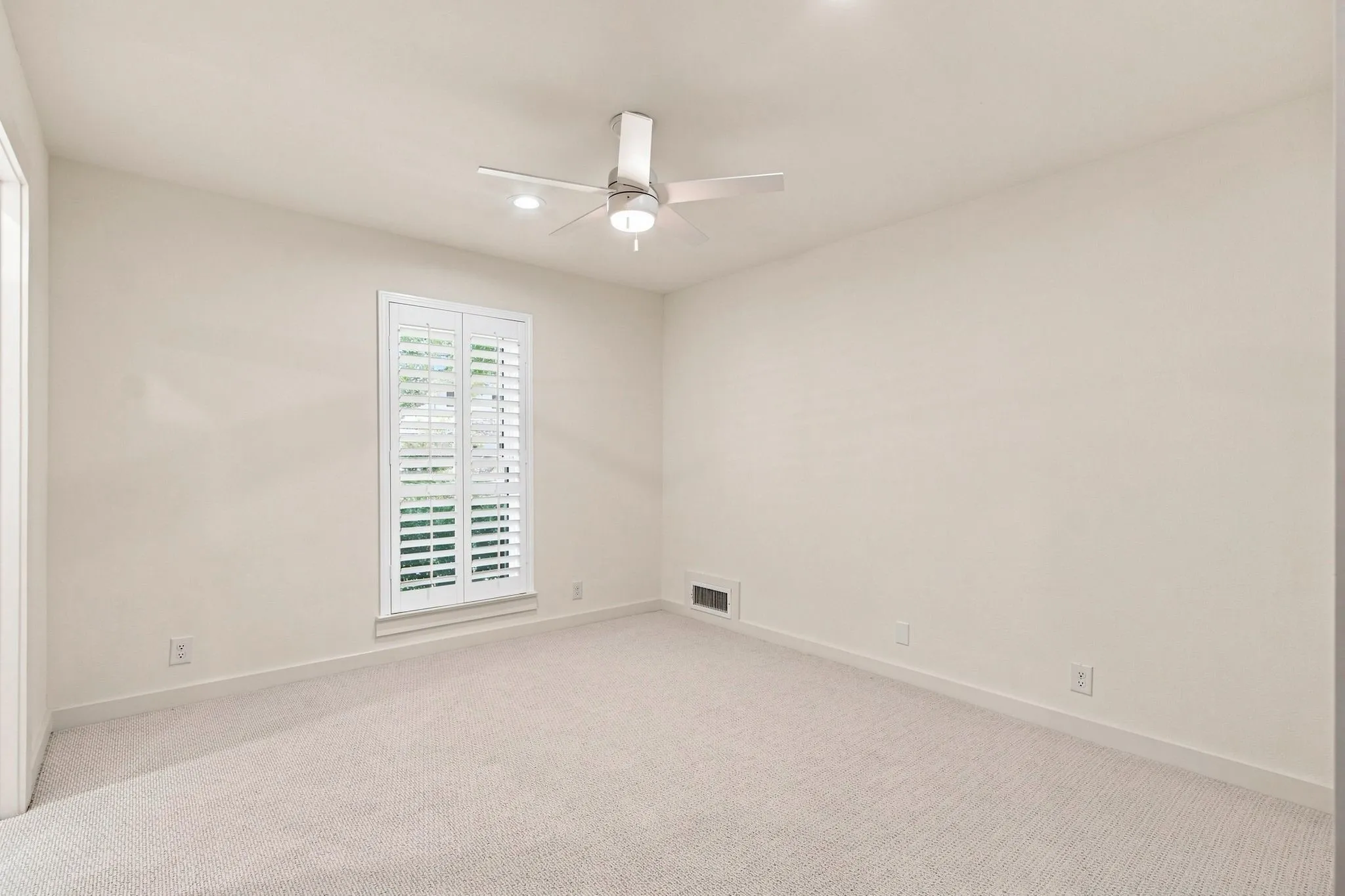 Window with white plantation shutters, ceiling fan with integrated lighting, recessed lighting, and carpeted flooring