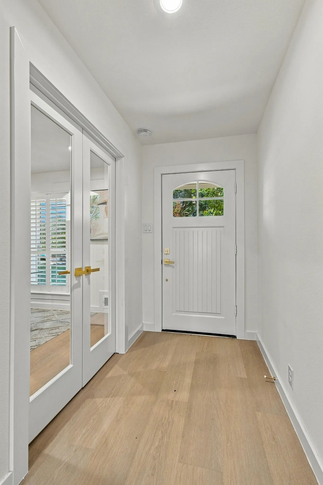 Entry with LVP flooring - office with double doors with glass.