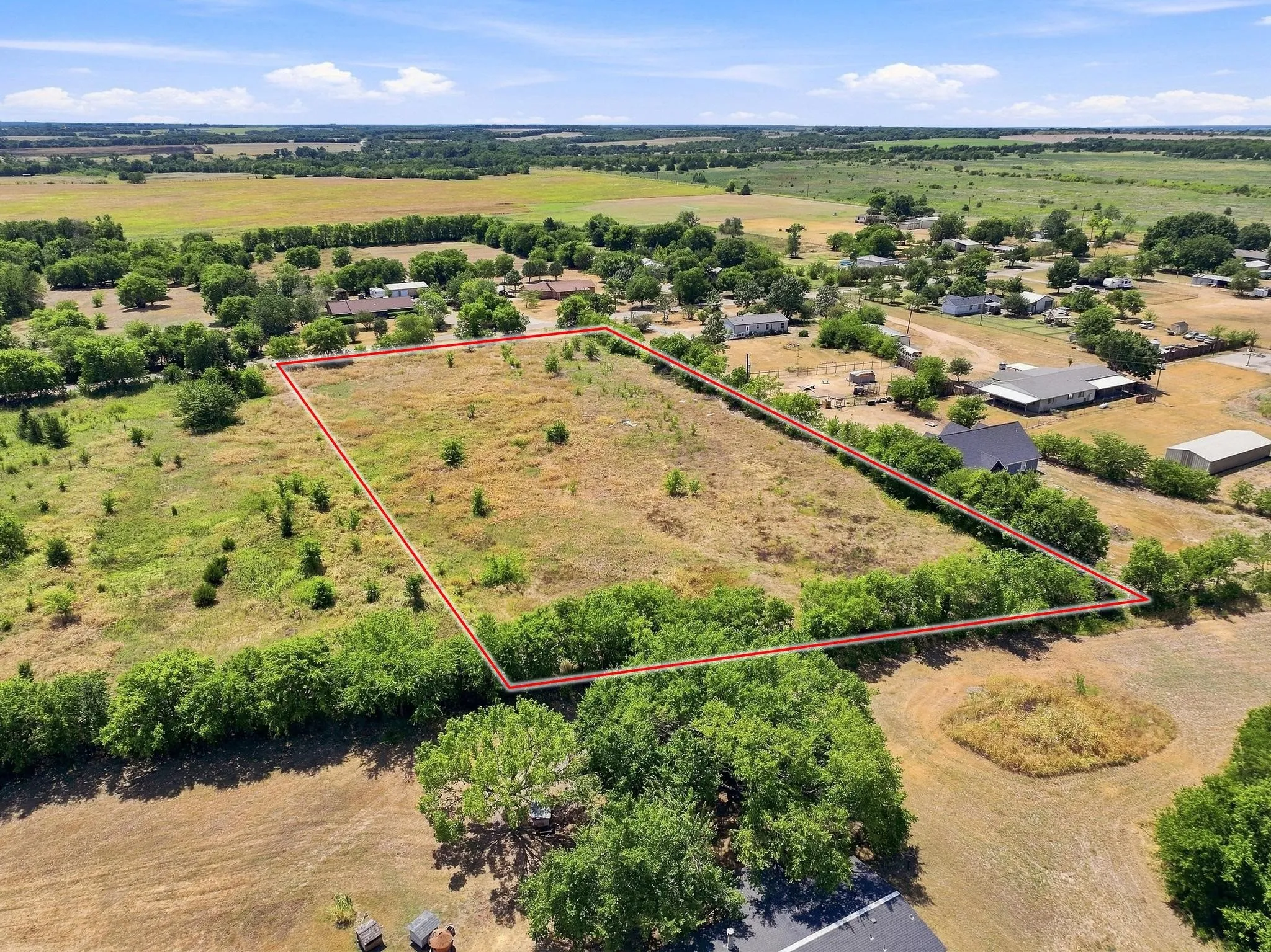 Expansive parcel with clear boundaries, surrounded by mature trees and natural landscaping