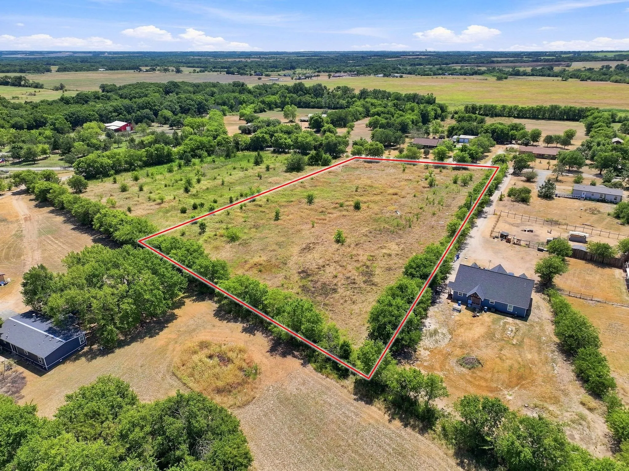 Expansive land parcel with surrounding foliage and clear boundaries