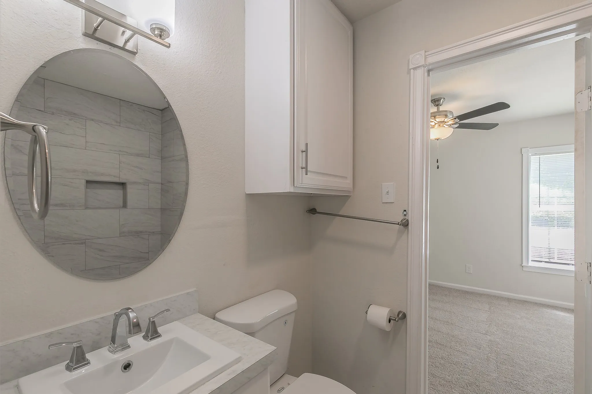 Bathroom with a vessel sink, marble-finish countertop, and brushed nickel fixtures
