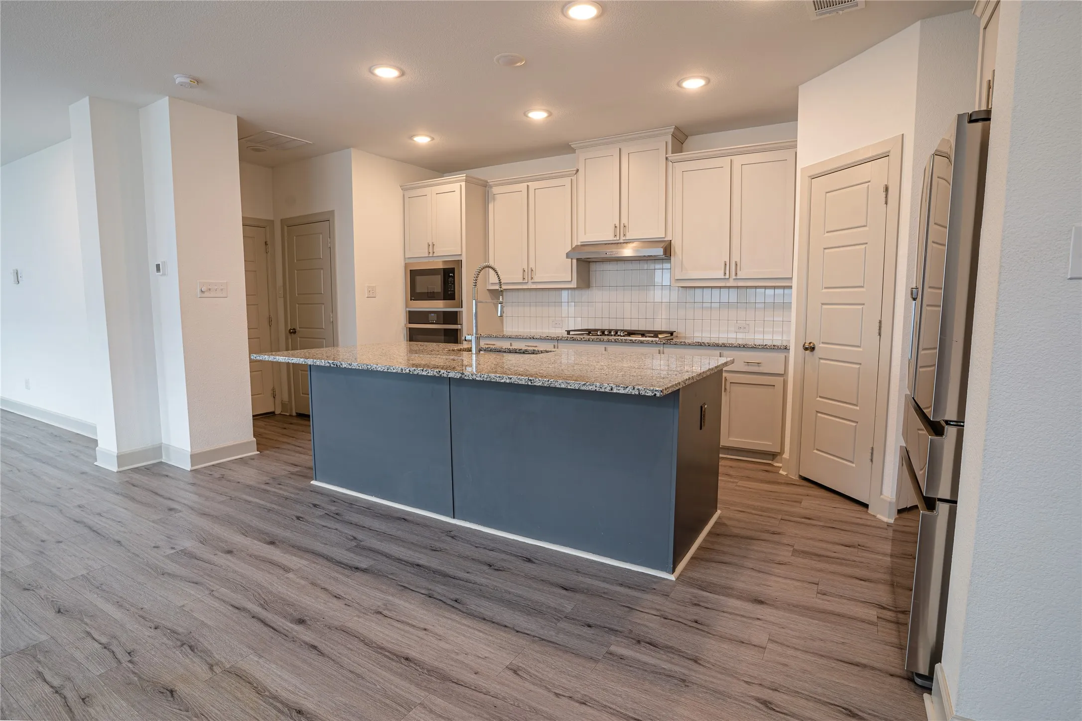 Modern kitchen island with a granite countertop, undermount sink, and integrated dishwasher