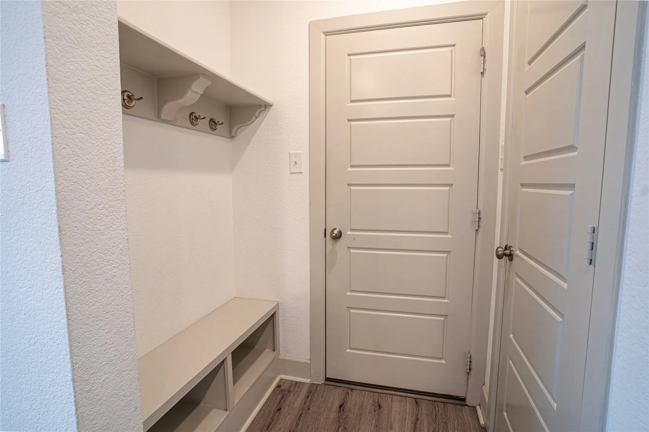 Built-in bench with open storage, shelving, and coat hooks