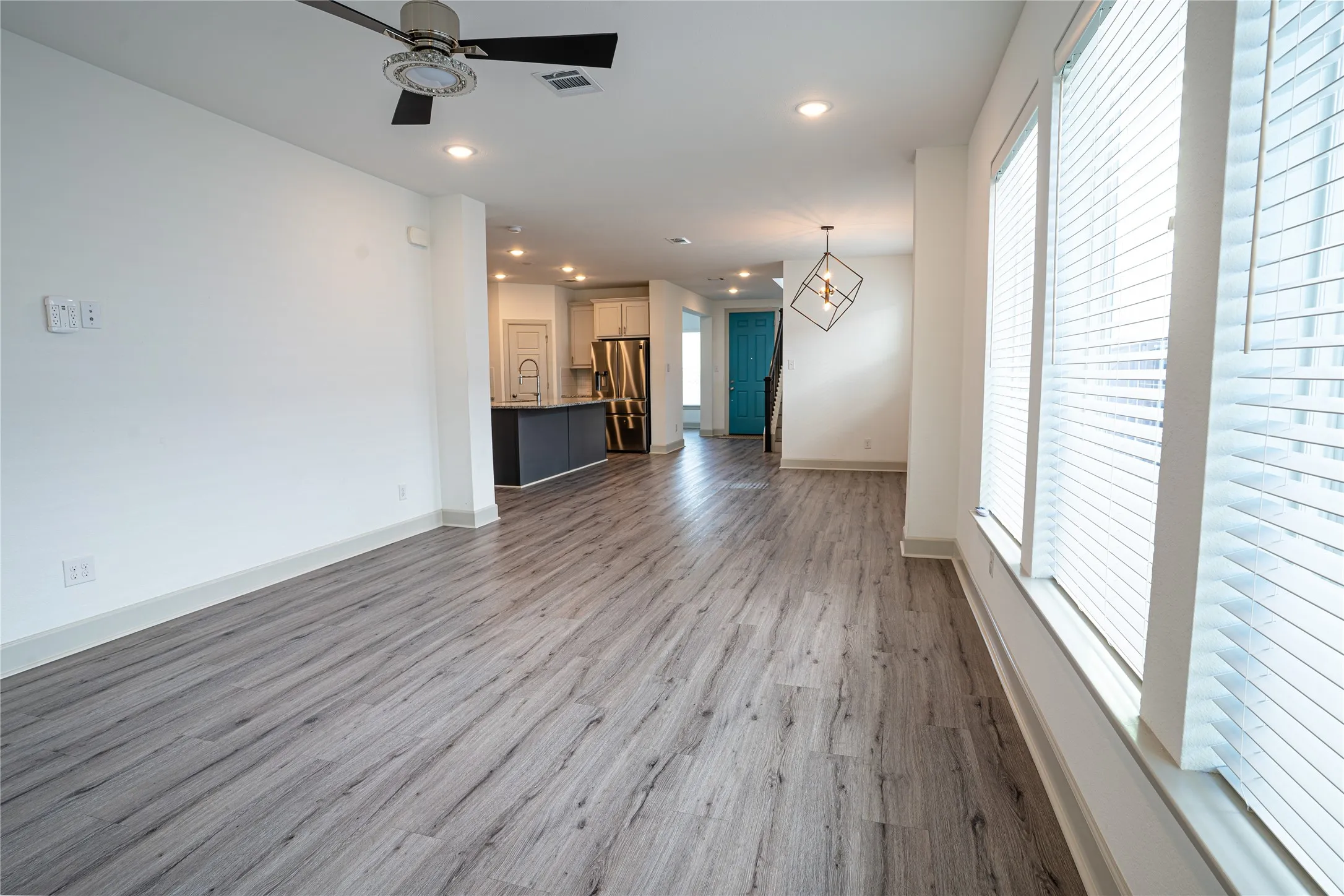 Wood-finish flooring throughout, recessed lighting, and a modern ceiling fan