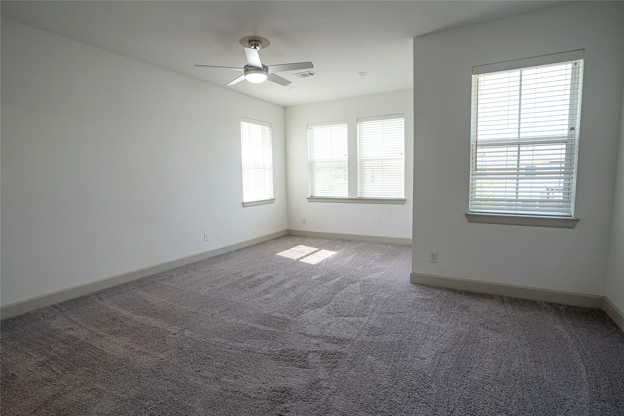 Plush carpeting, multiple windows with blinds, recessed lighting, and a ceiling fan
