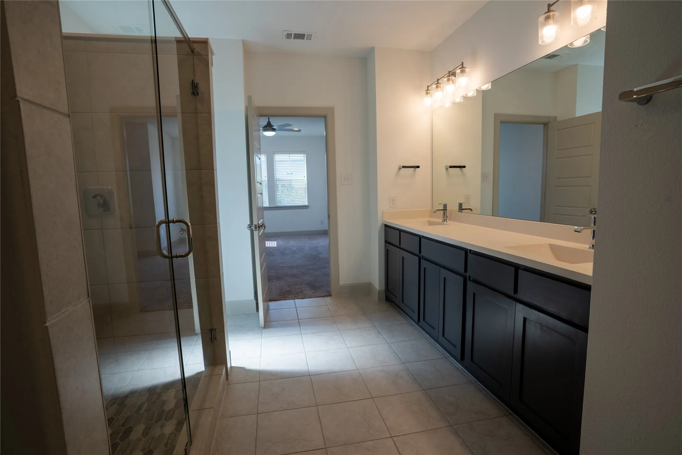 Dual vanity with dark wood-finish cabinetry, light-toned countertop, and undermount sinks