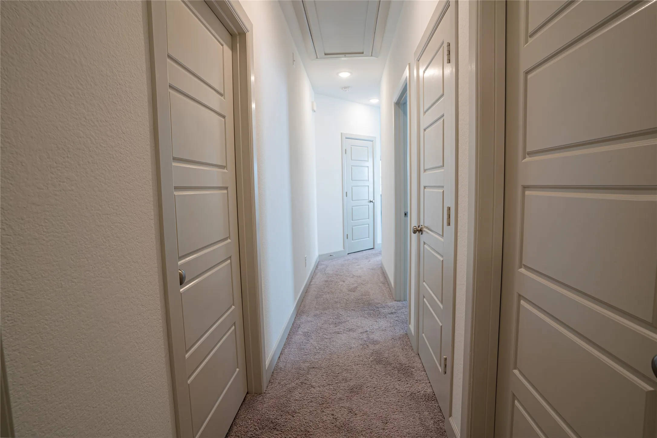 Hallway with textured walls, recessed lighting, and carpet flooring