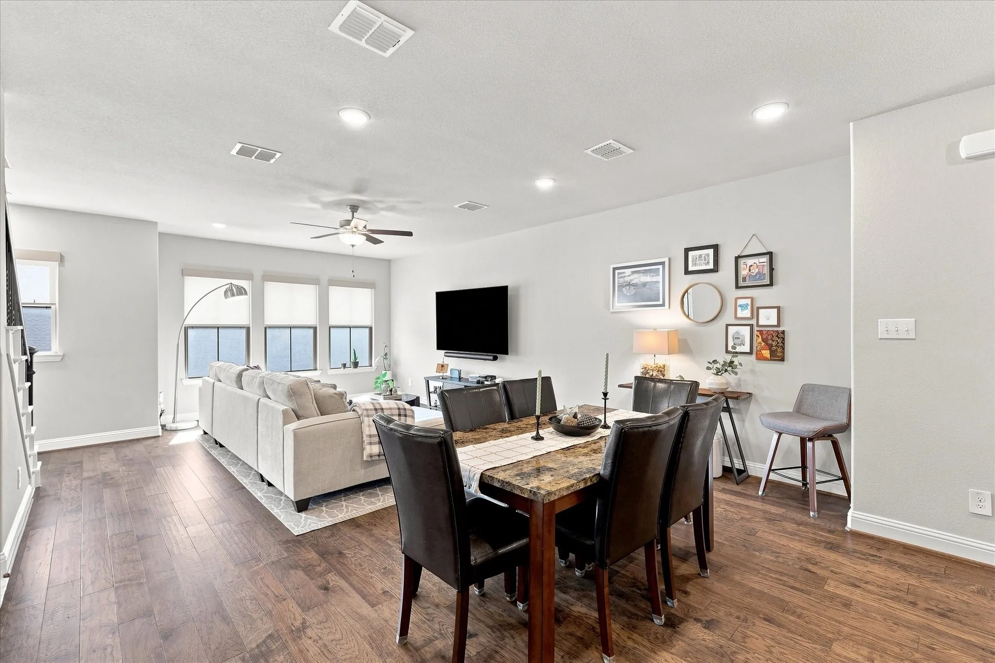 Open-concept living space with wood-finish flooring, recessed lighting, and a ceiling fan