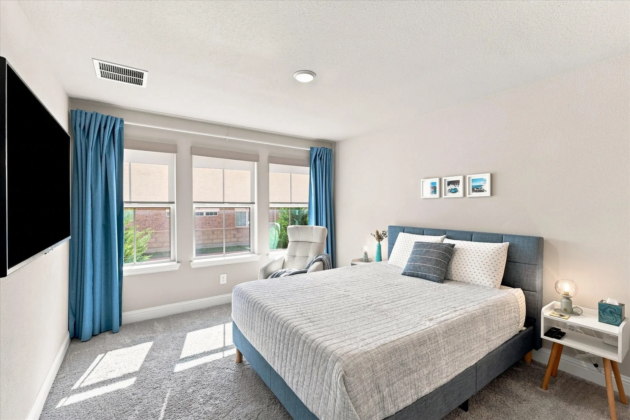 Plush carpet flooring, recessed ceiling lighting, triple window arrangement, and a textured headboard