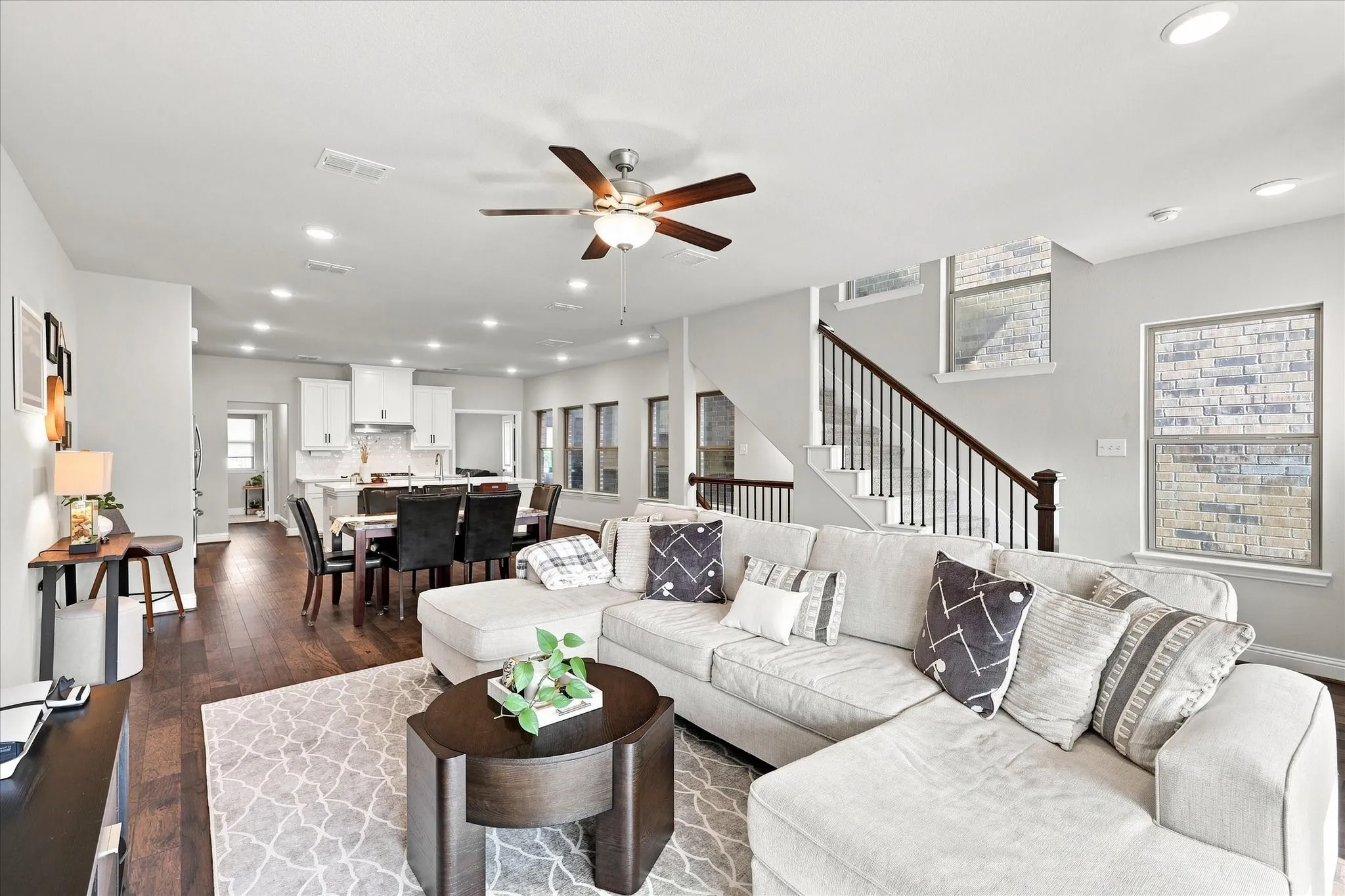 Open-concept living space with dark wood-finish flooring, recessed lighting, and a ceiling fan