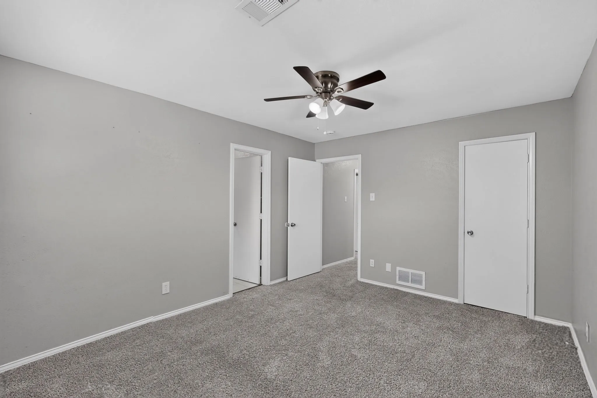 Plush carpet flooring, neutral paint palette, white trim, and a ceiling fan with integrated lighting