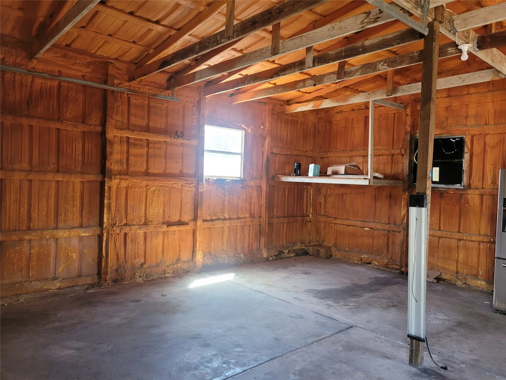 Insulated garage workshop with electricity and concrete floor.