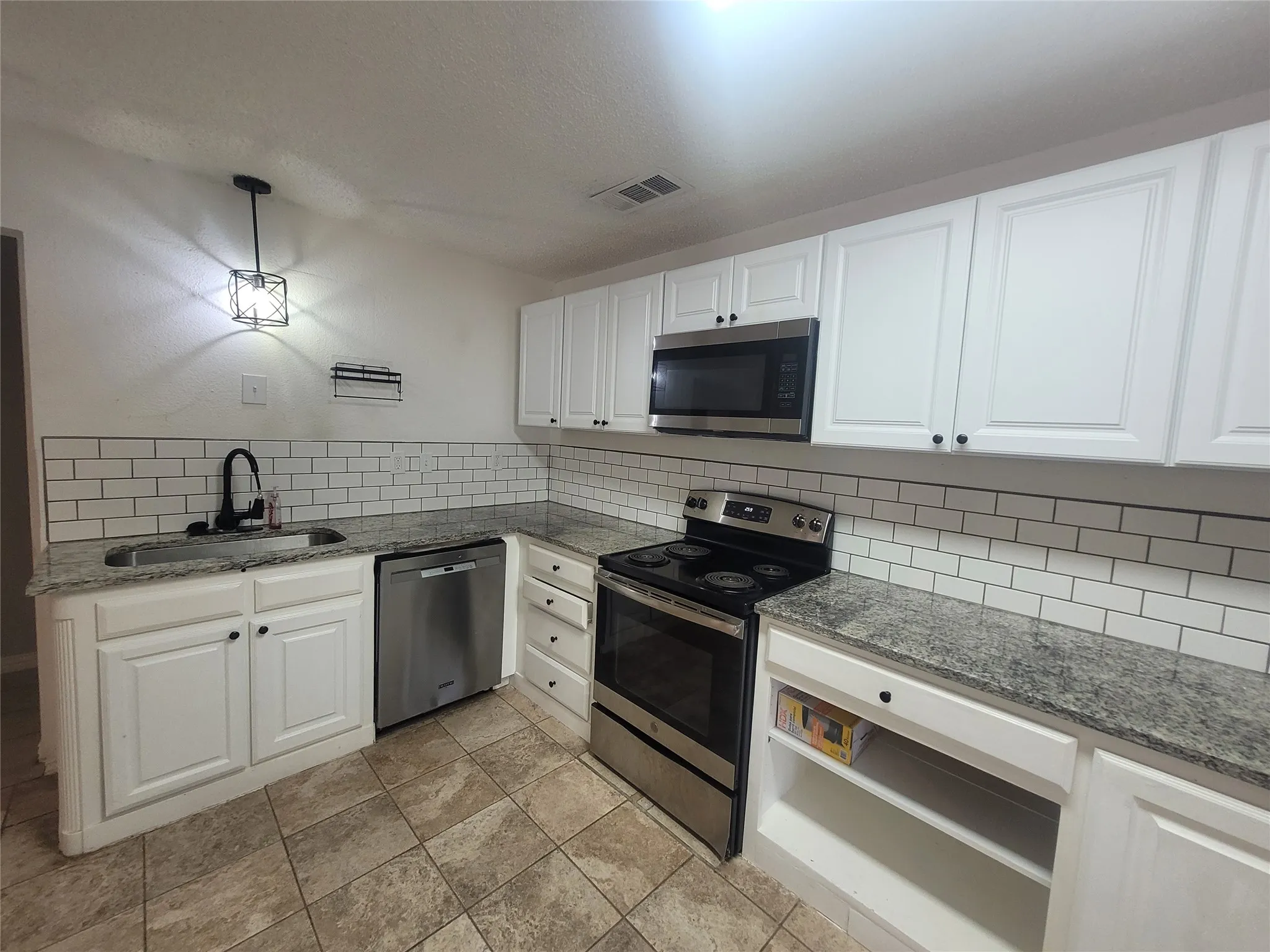 Granite counter tops and tile backsplash plus dishwasher, microwave, and electric range Refrigerator too.