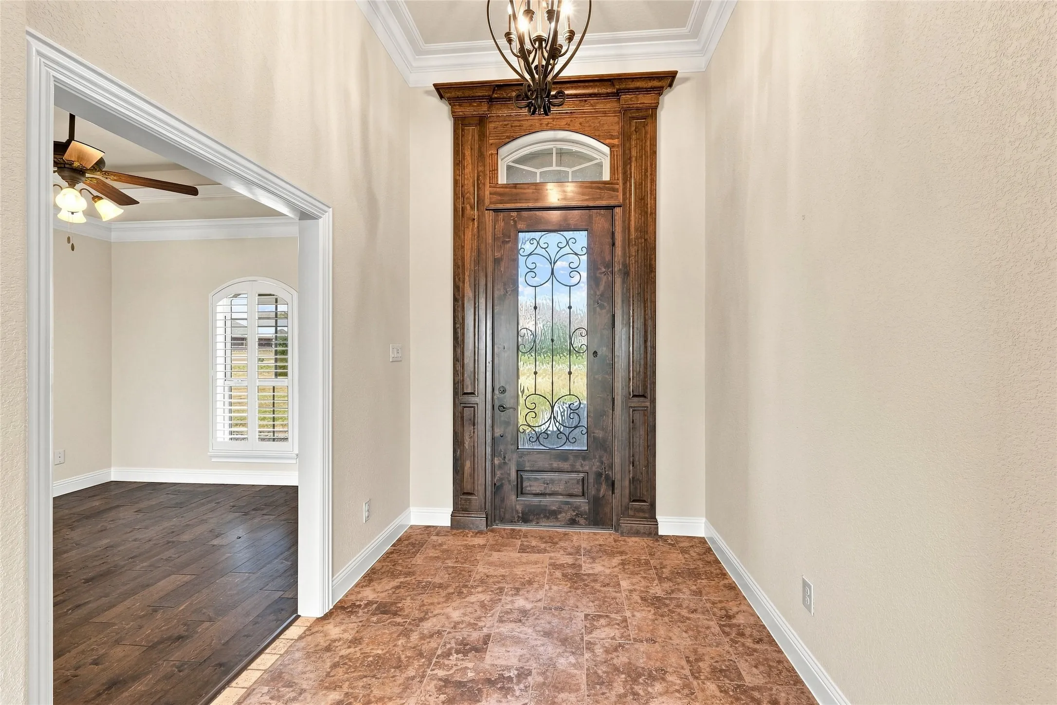 Arched wood-finish entry door with decorative glass and transom window