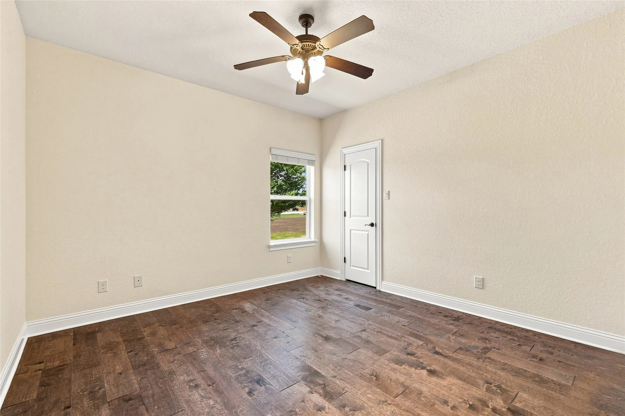 Hardwood-style flooring, white trim, recessed window, and ceiling fan with integrated lighting