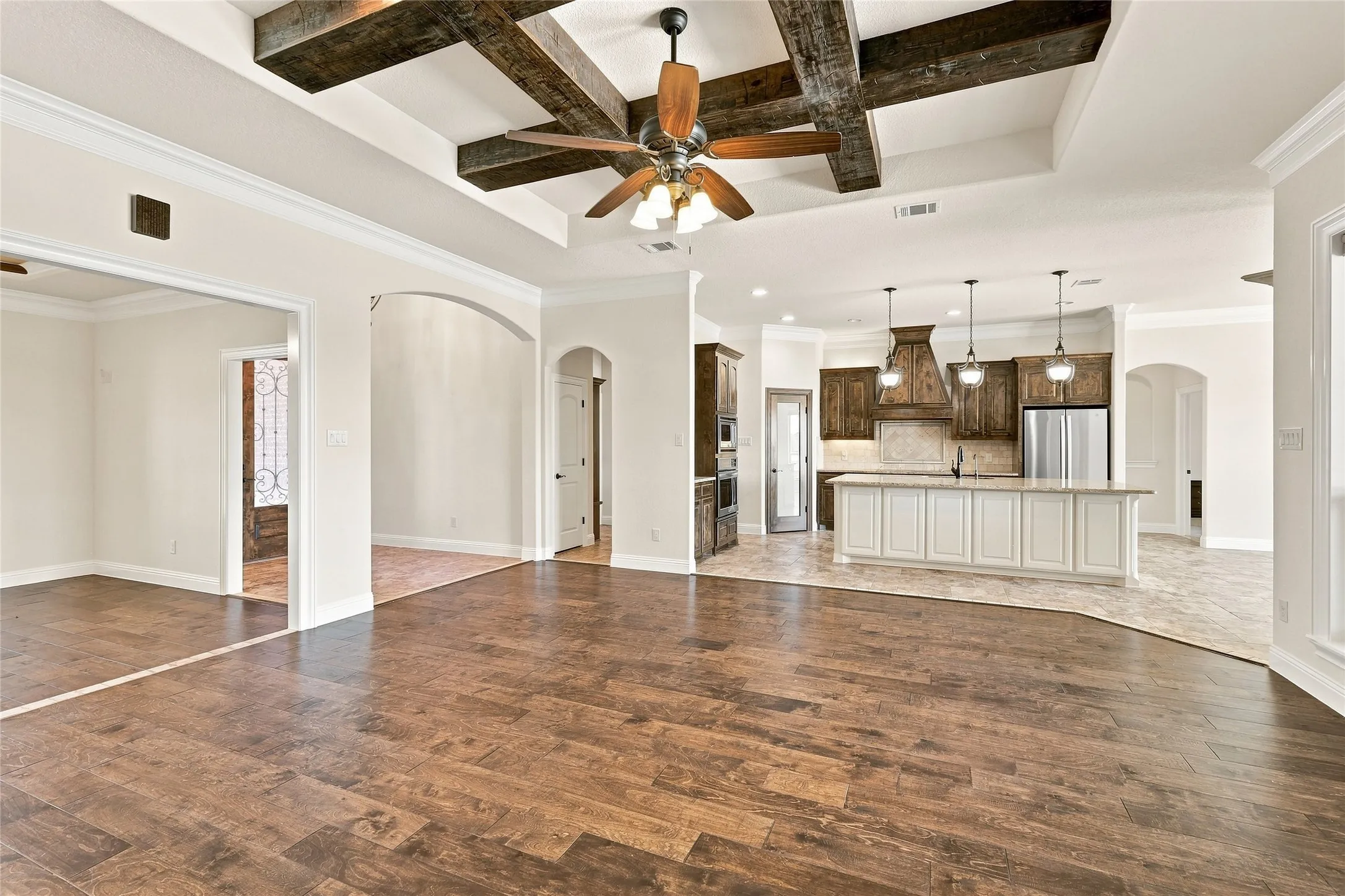 Vaulted ceiling with exposed wood beams, wood-finish flooring, recessed lighting, and a ceiling fan