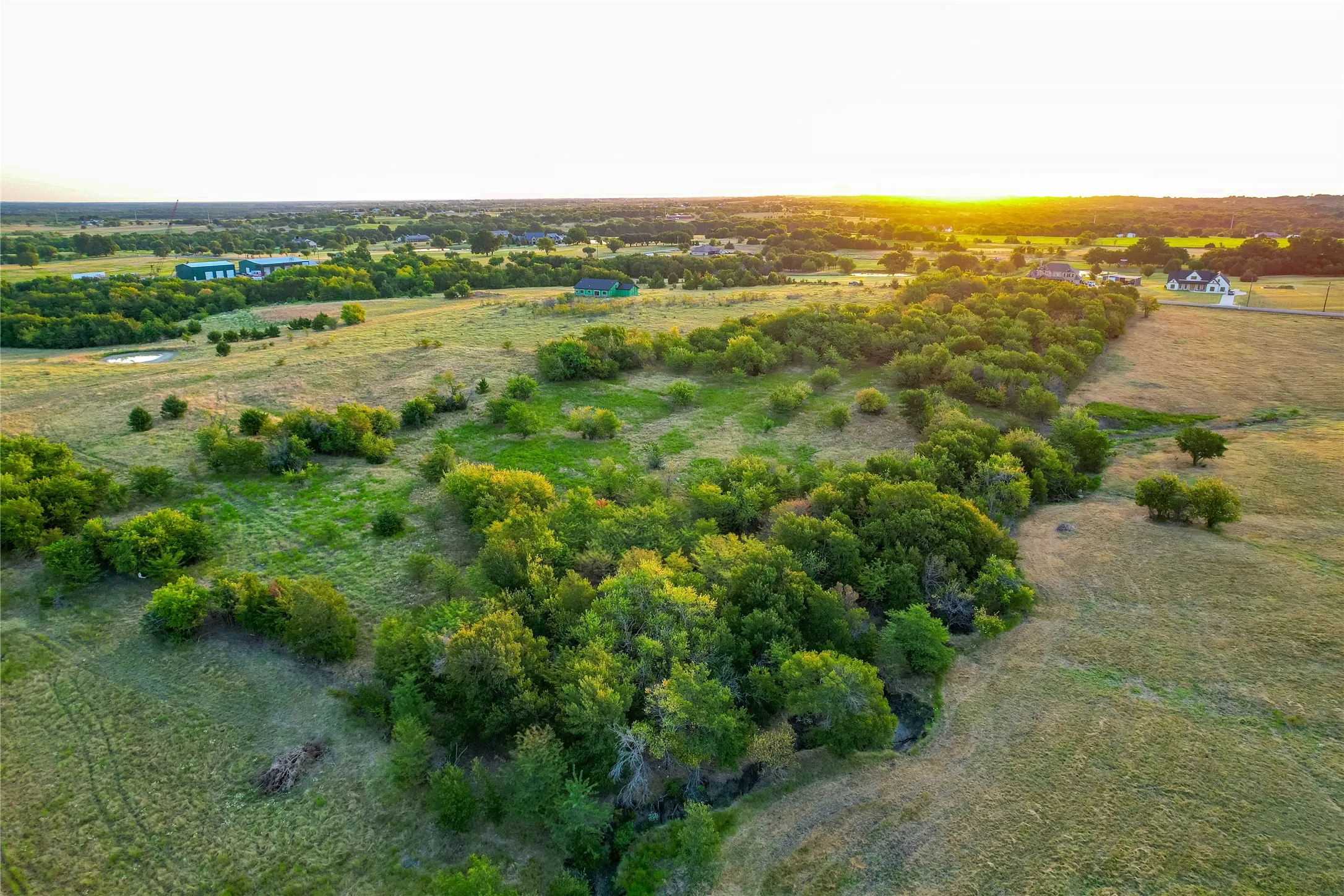 Expansive rural landscape featuring lush trees and open fields