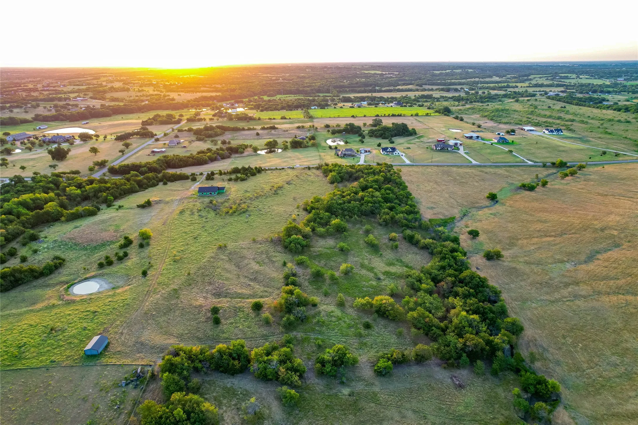Expansive landscape featuring large parcels of land, diverse topography, and scattered trees