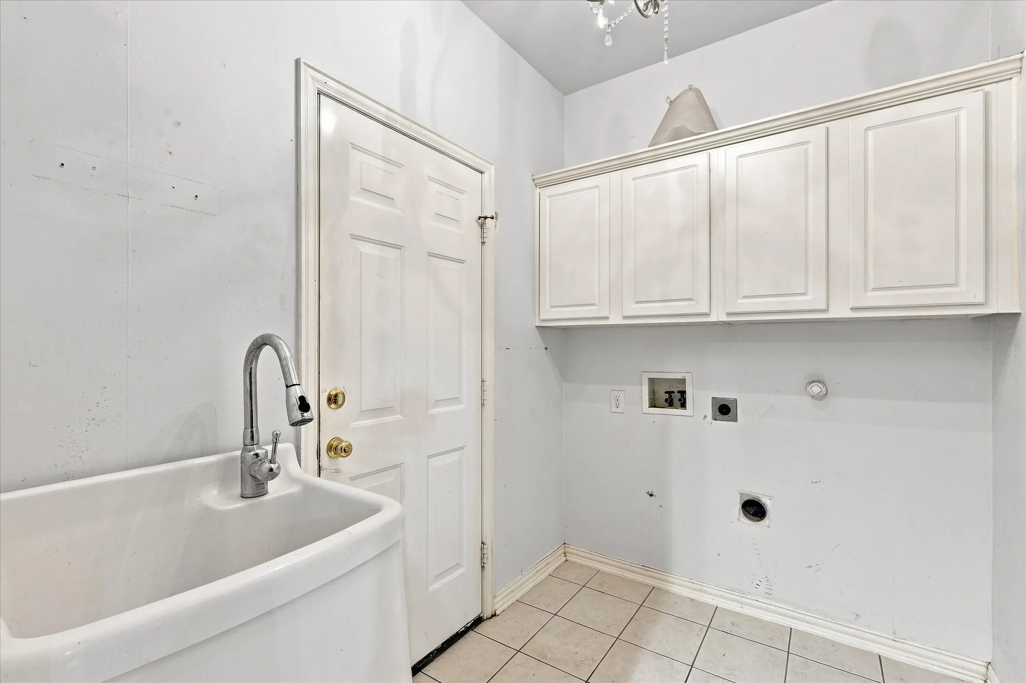 Laundry room with built-in cabinets and utility sink