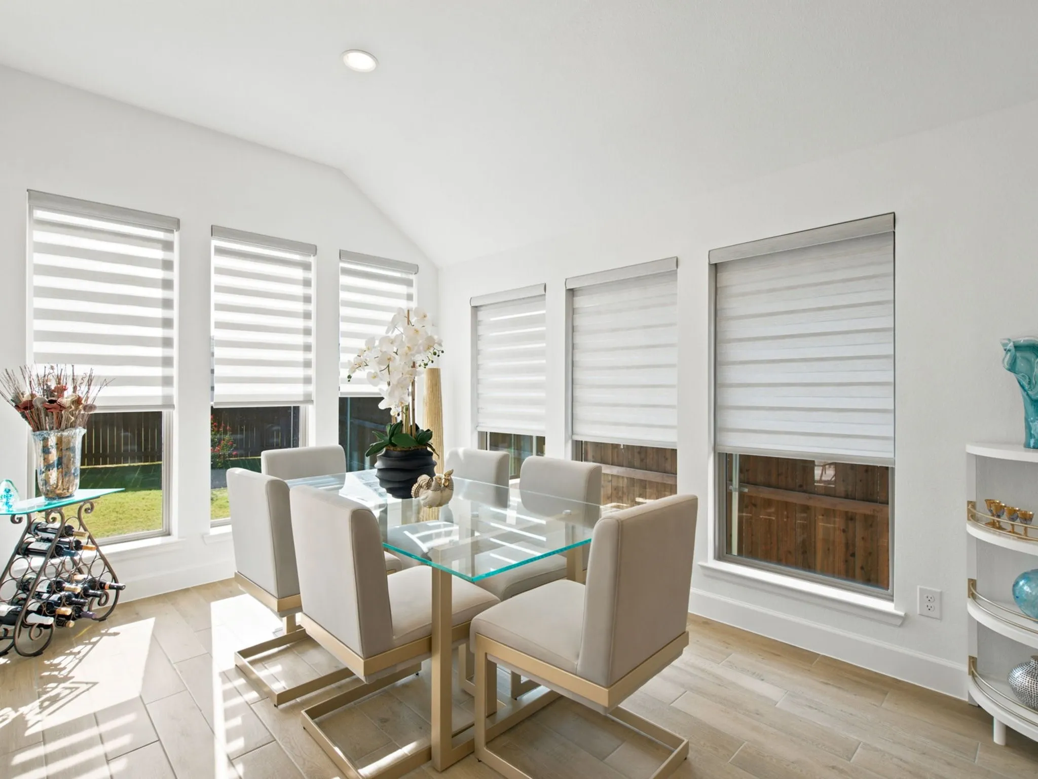 Vaulted ceiling, recessed lighting, multiple windows with blinds, wood-finish flooring, built-in shelving