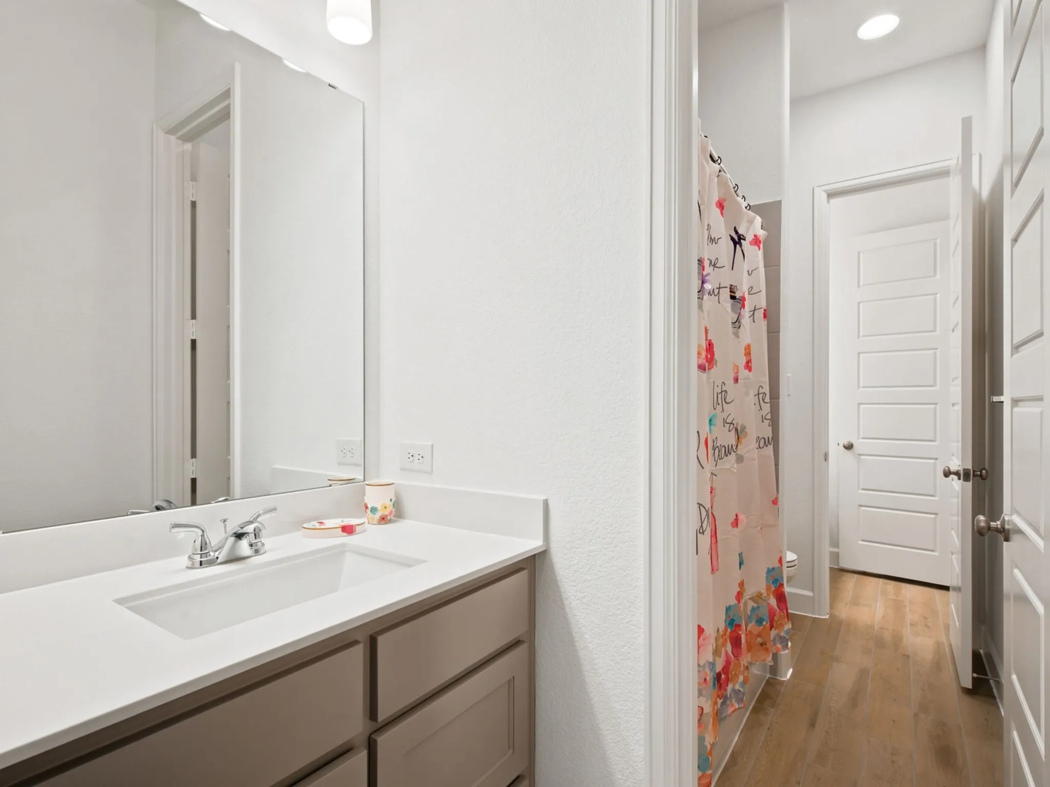 Bathroom vanity with an integrated rectangular sink, chrome faucet, and neutral cabinetry