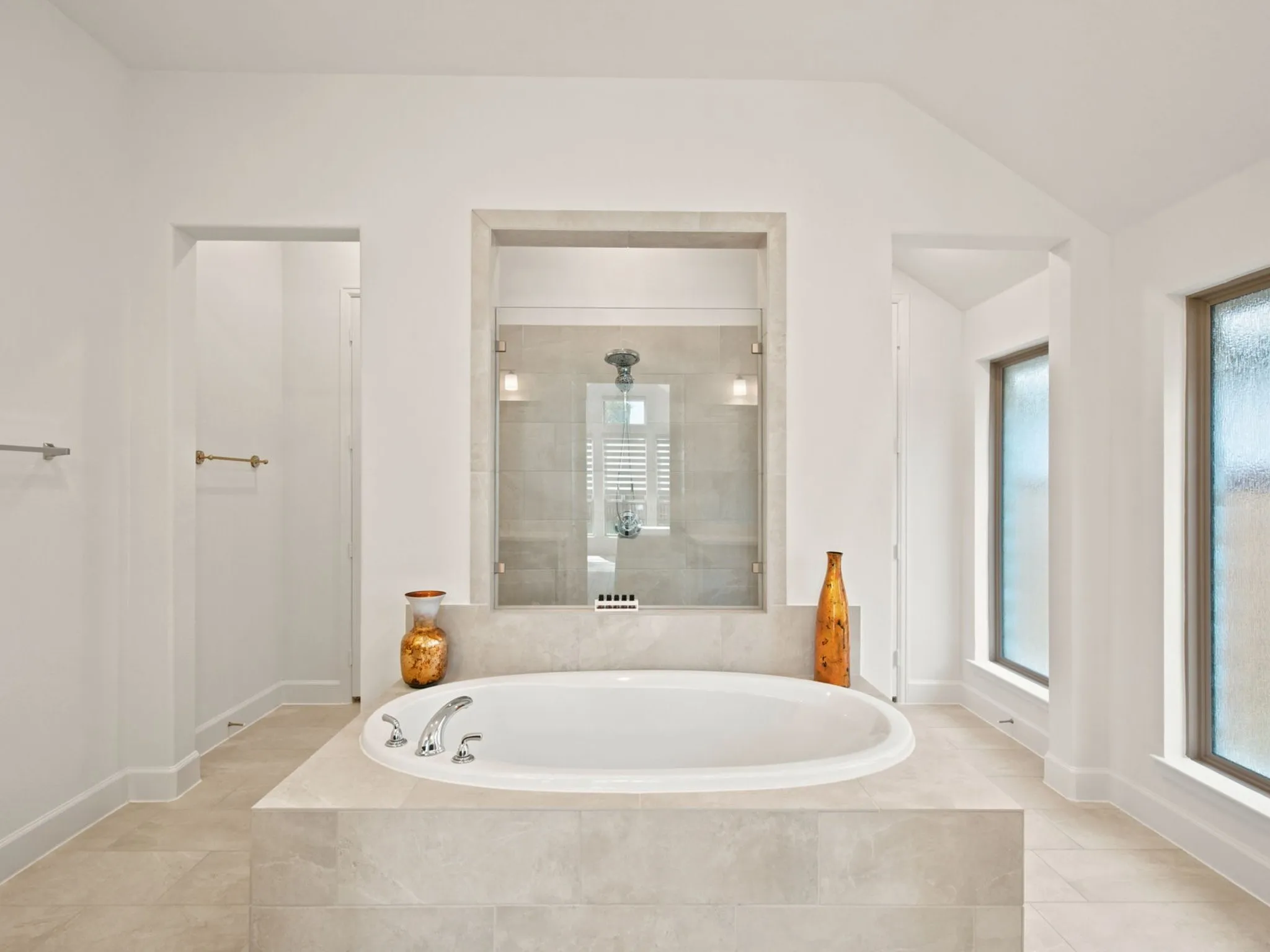 Deep soaking tub with chrome fixtures, tiled surround, glass-enclosed shower, and opaque window panels