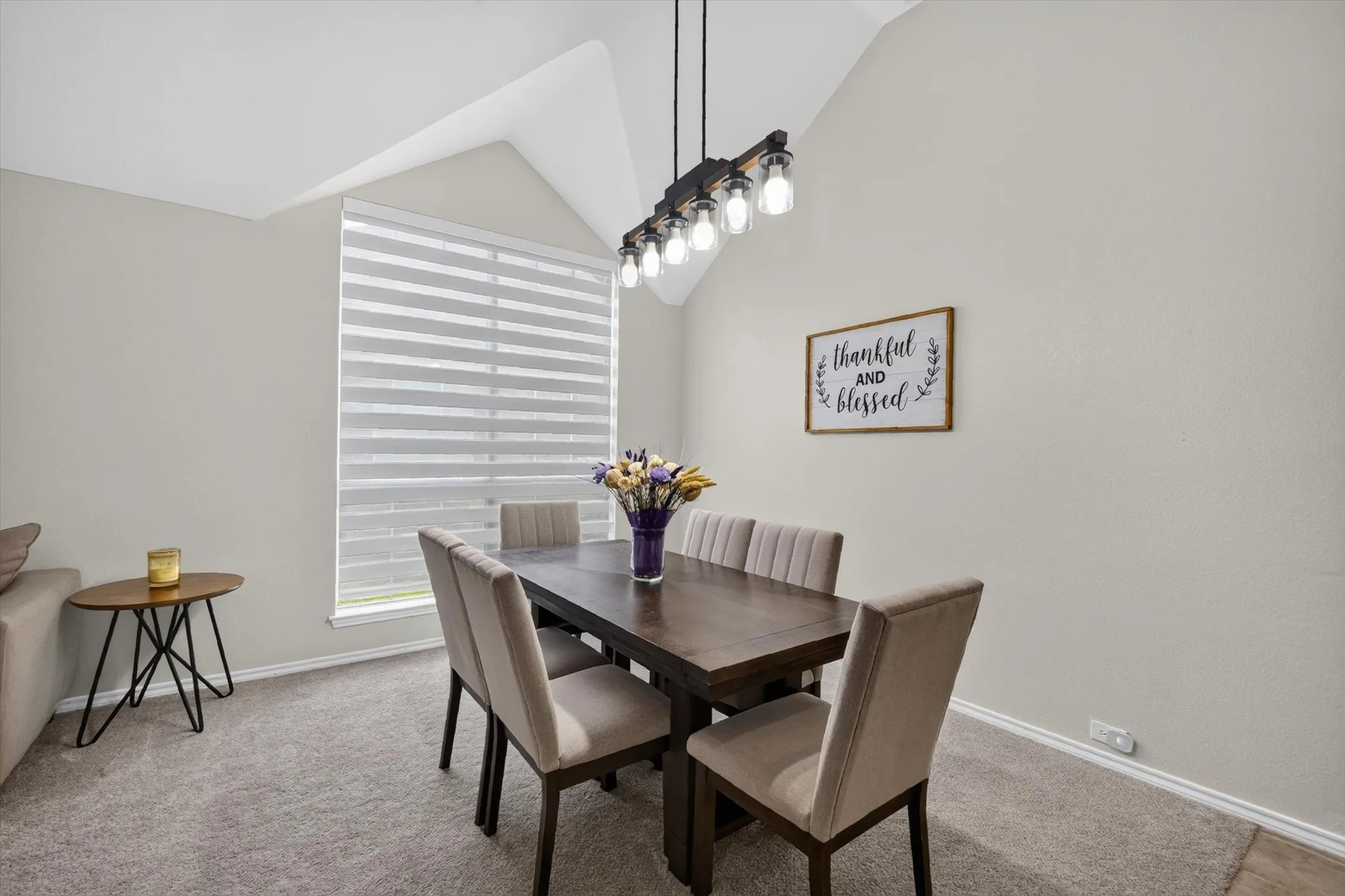 Dining area featuring a vaulted ceiling and a contemporary linear chandelier