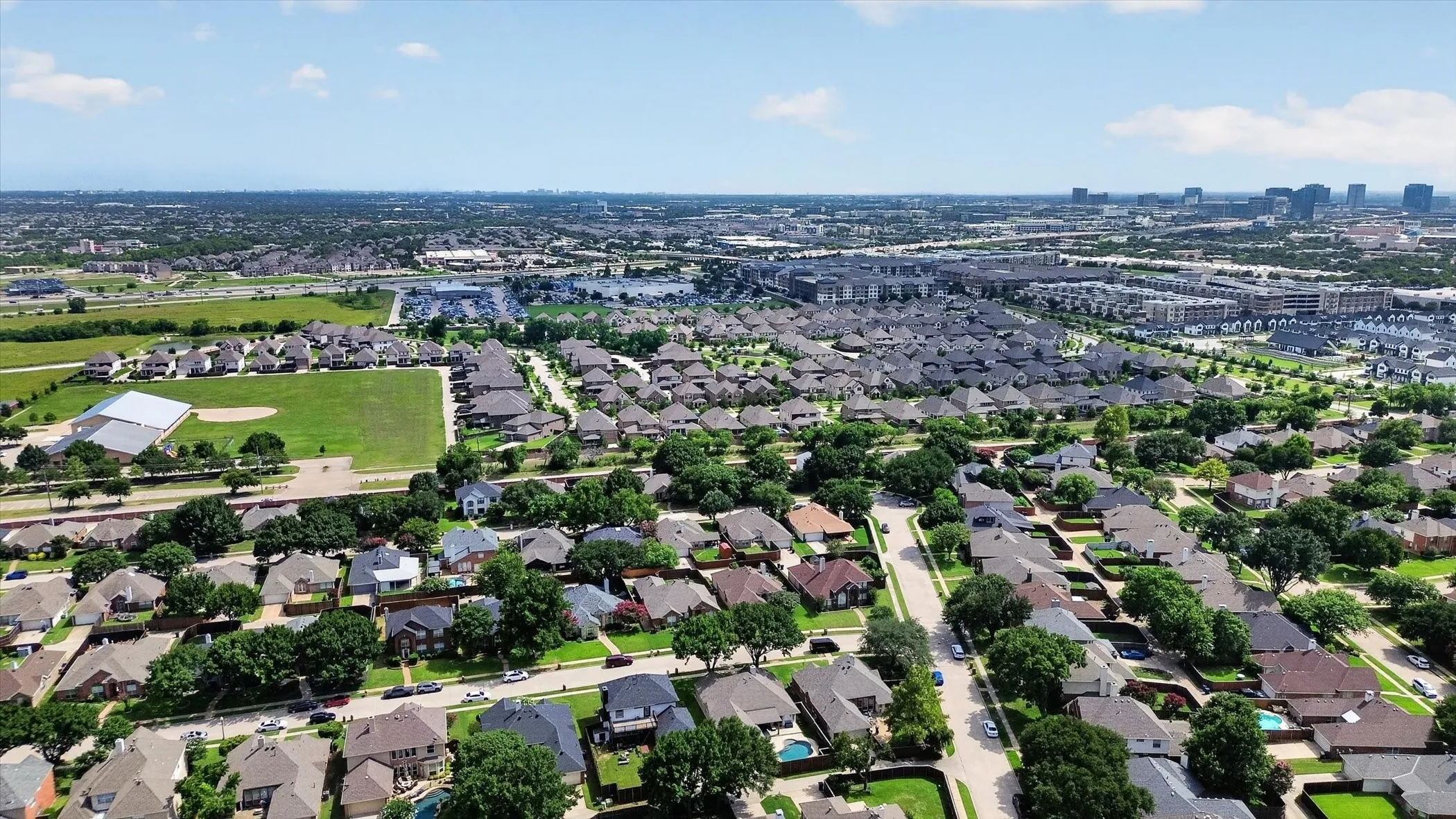 Expansive suburban landscape featuring a dense residential area with single-family homes and mature trees