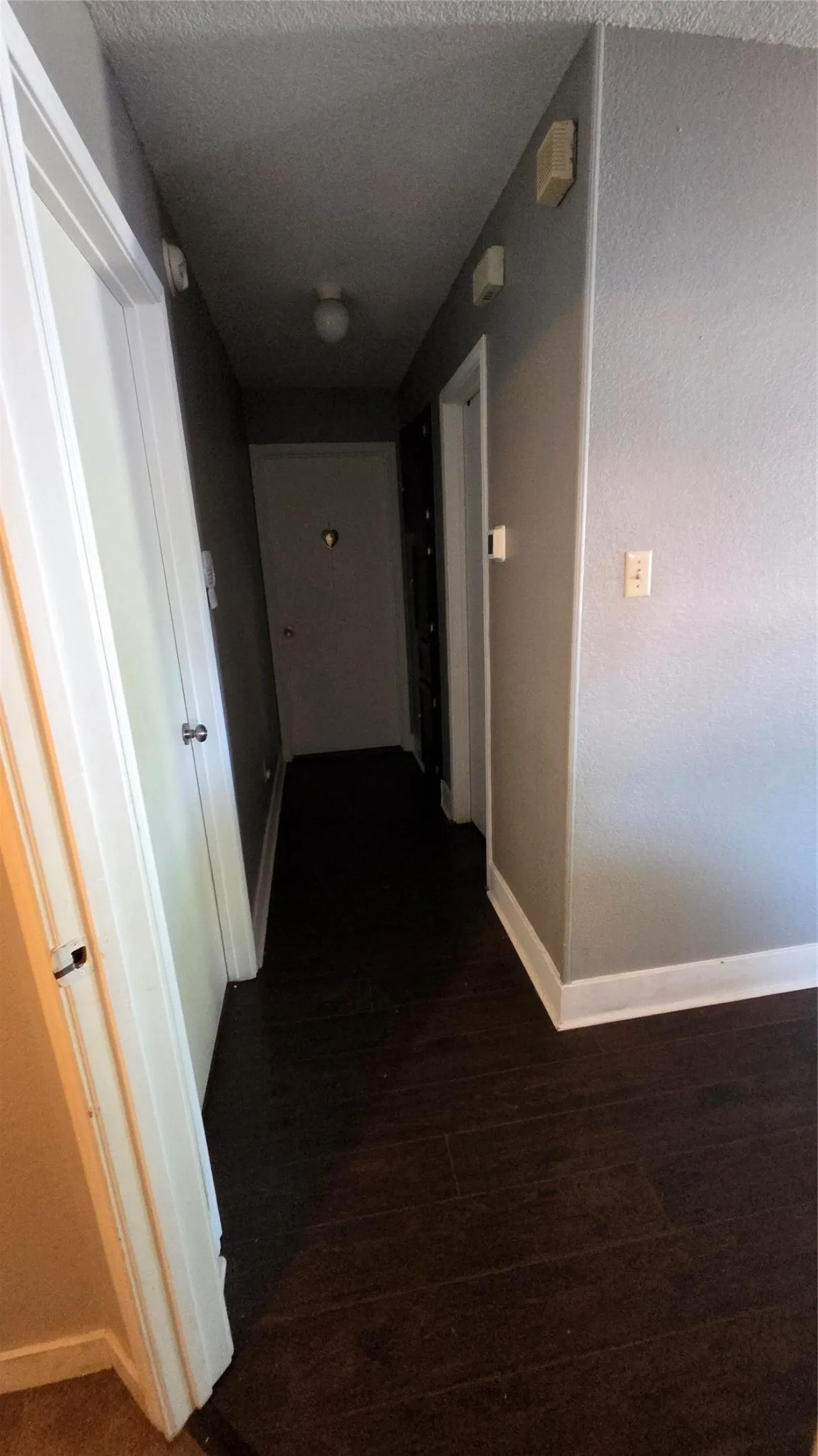 Wood-finish flooring with white trim and grey painted walls