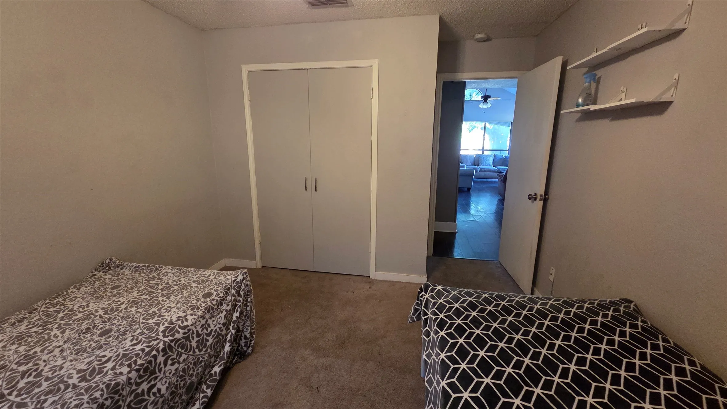 Neutral wall finishes with a built-in closet and permanent wall shelving