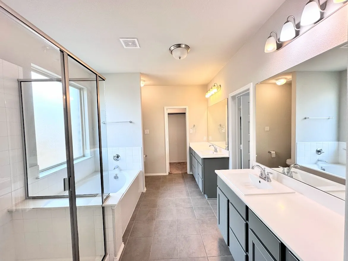 Master bath with 2 expansive vanities and 2 huge his and hers walk in closets