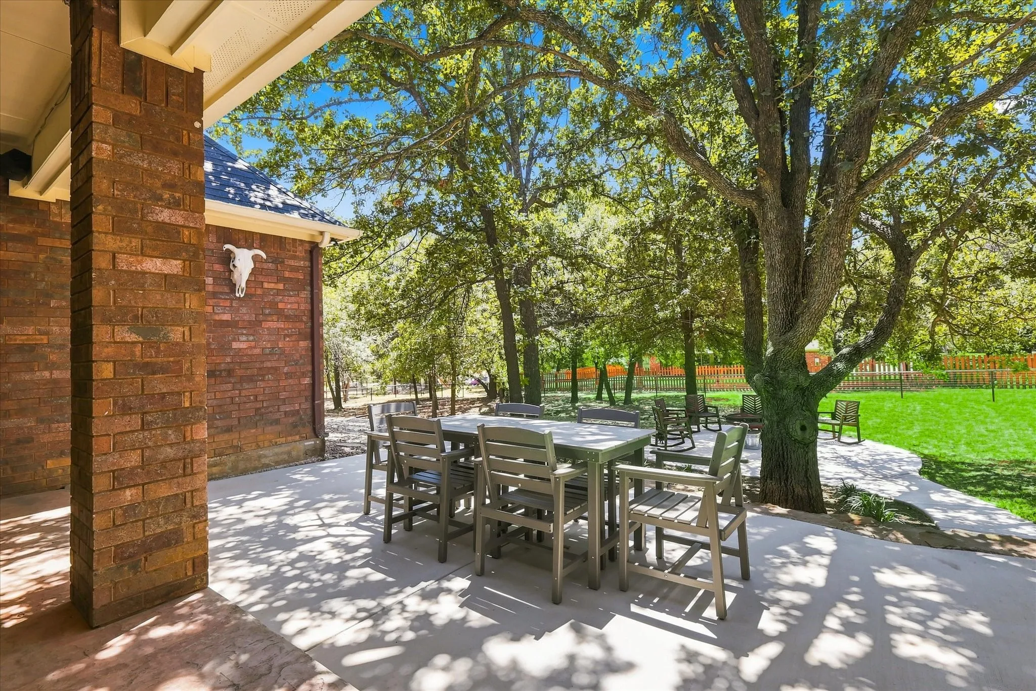 Expansive concrete patio area with brick columns and a pitched roof