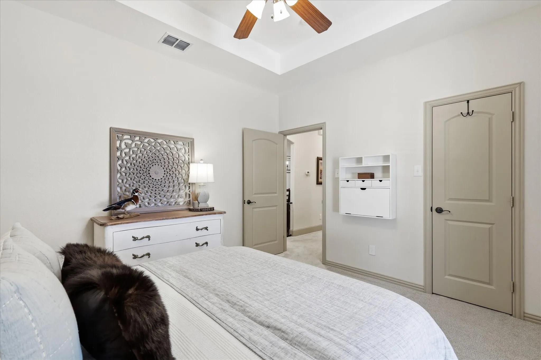 Tray ceiling, ceiling fan, neutral wall paint, carpeted flooring, two-panel doors