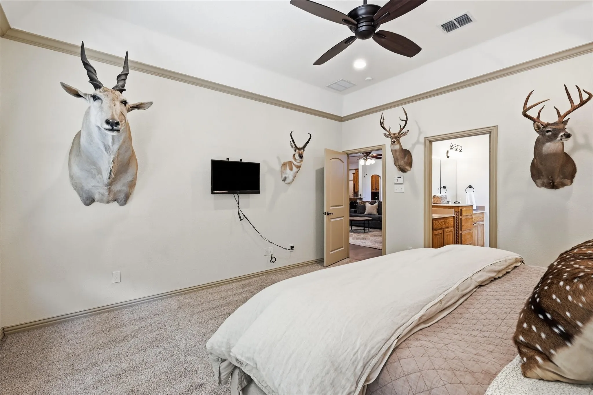 Neutral-toned walls with contrasting trim, carpeted flooring, and a ceiling fan with integrated lighting
