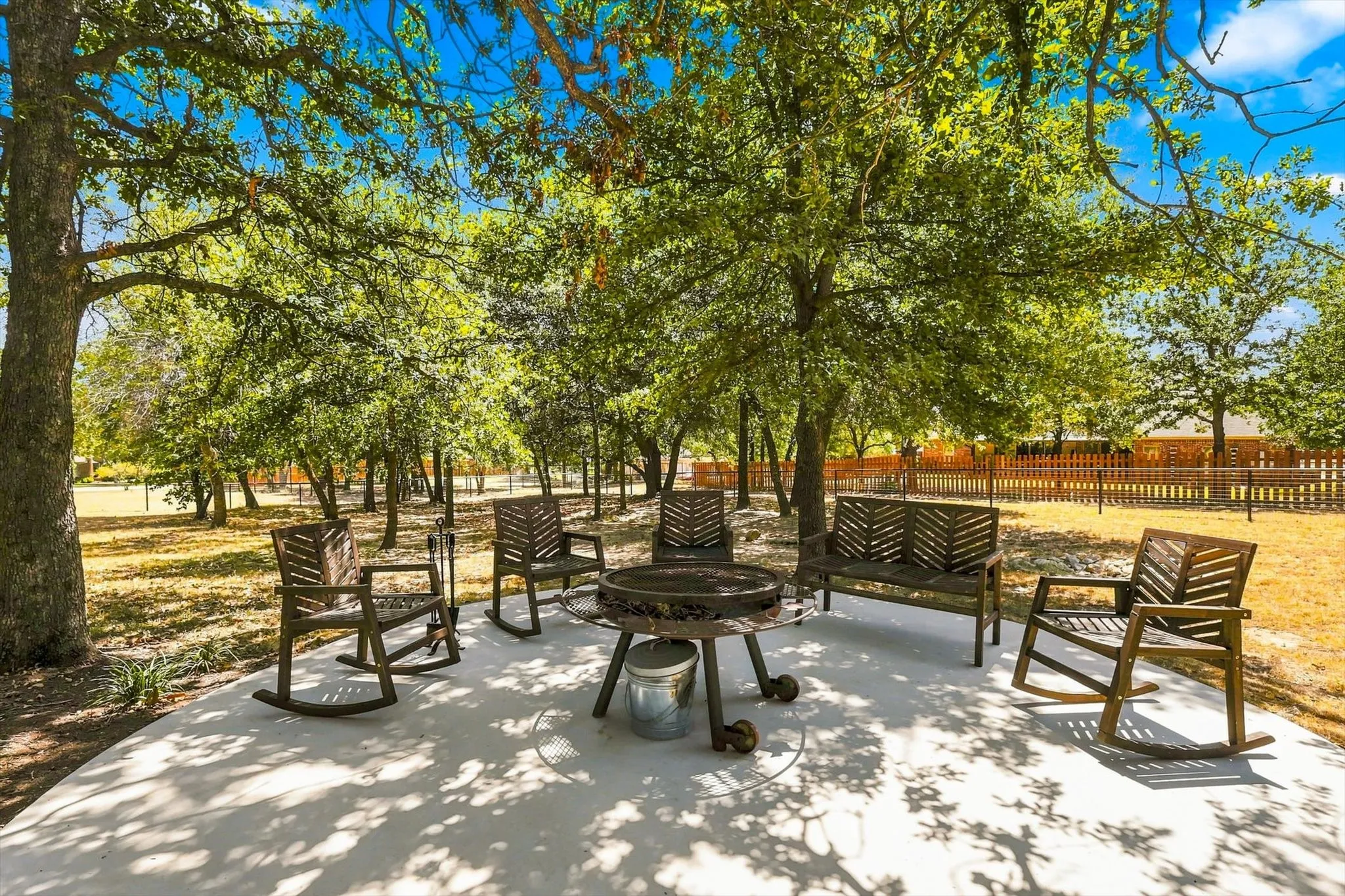 Concrete patio surrounded by mature trees