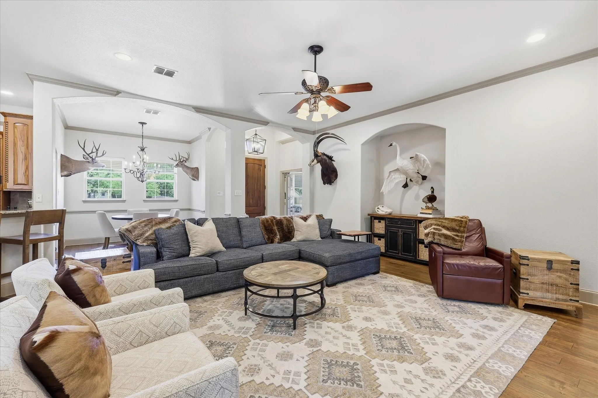 Hardwood-style flooring throughout, recessed lighting, arched doorways, ceiling fan, and built-in alcove shelving