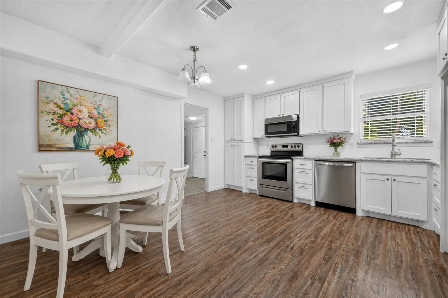 Virtually staged Kitchen with white cabinetry, stainless steel appliances, and light-toned countertops