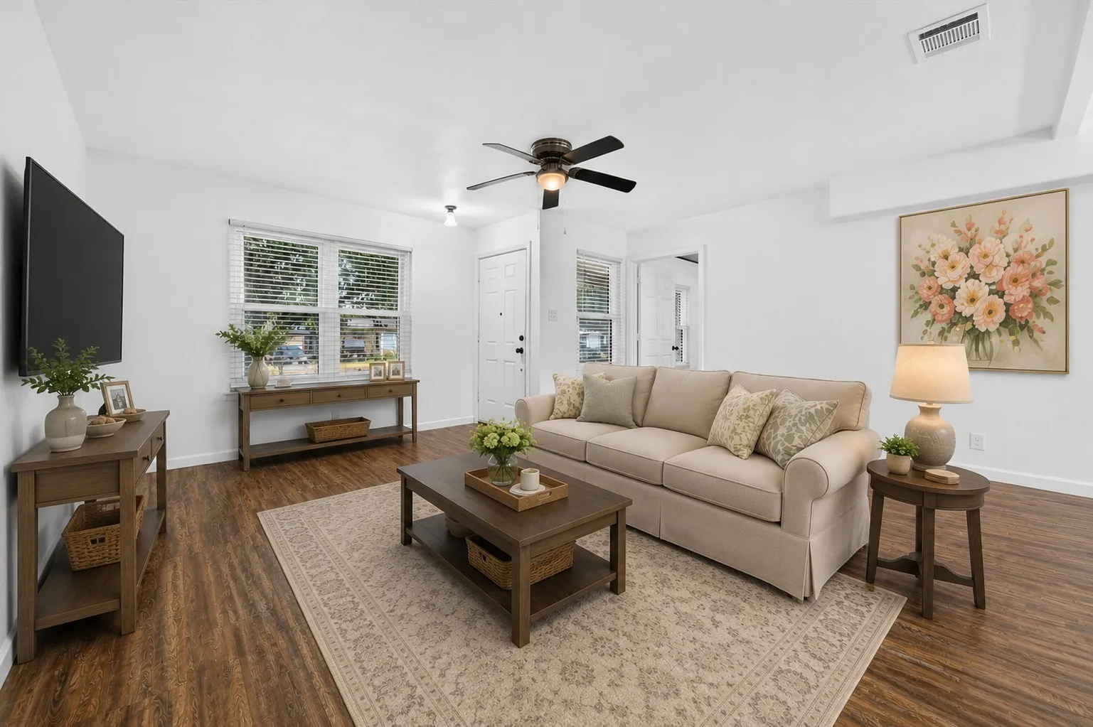 Virtually staged Spacious living area featuring wood-finish flooring, white walls, and a ceiling fan