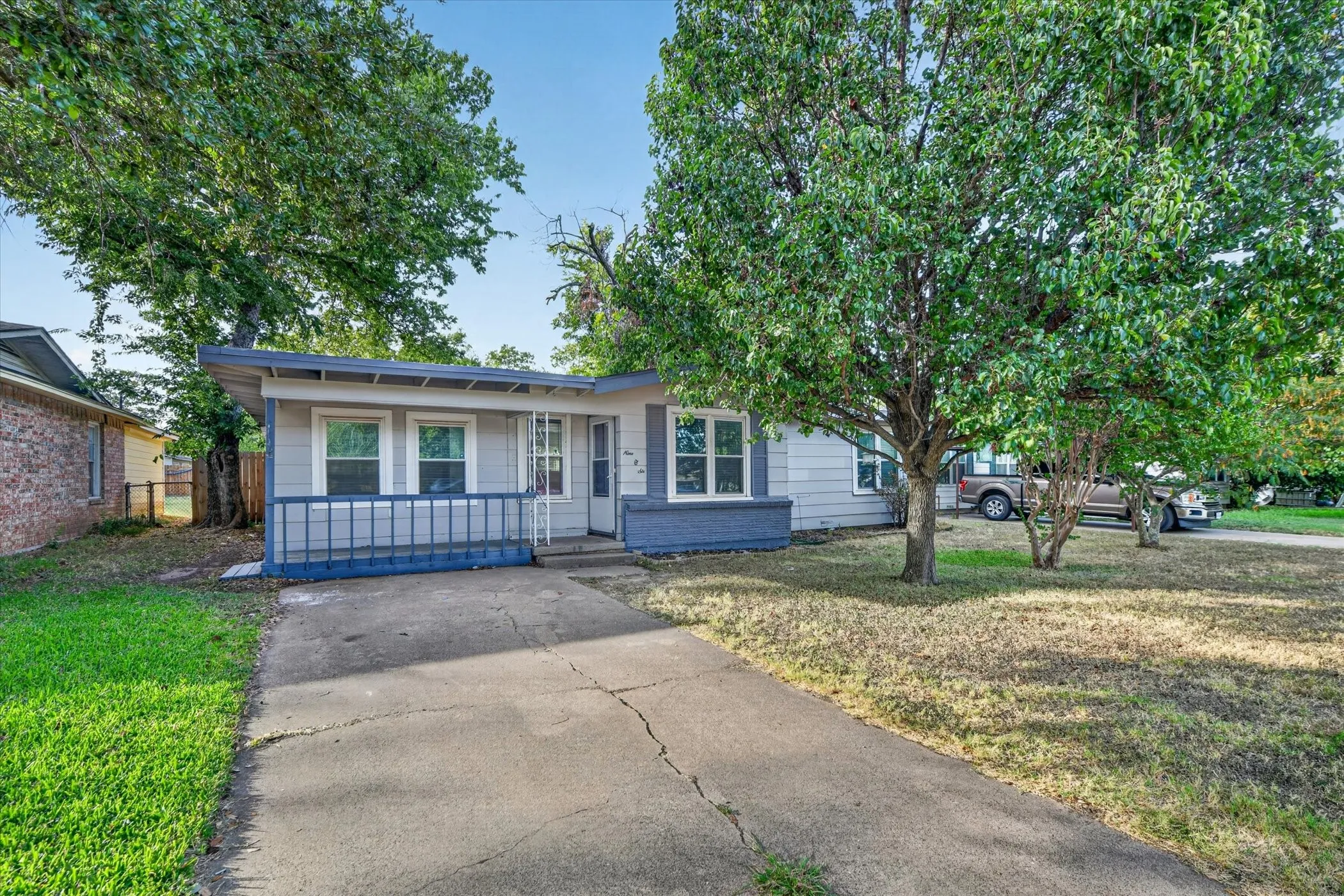 Gray siding exterior with white window trim and a covered entry