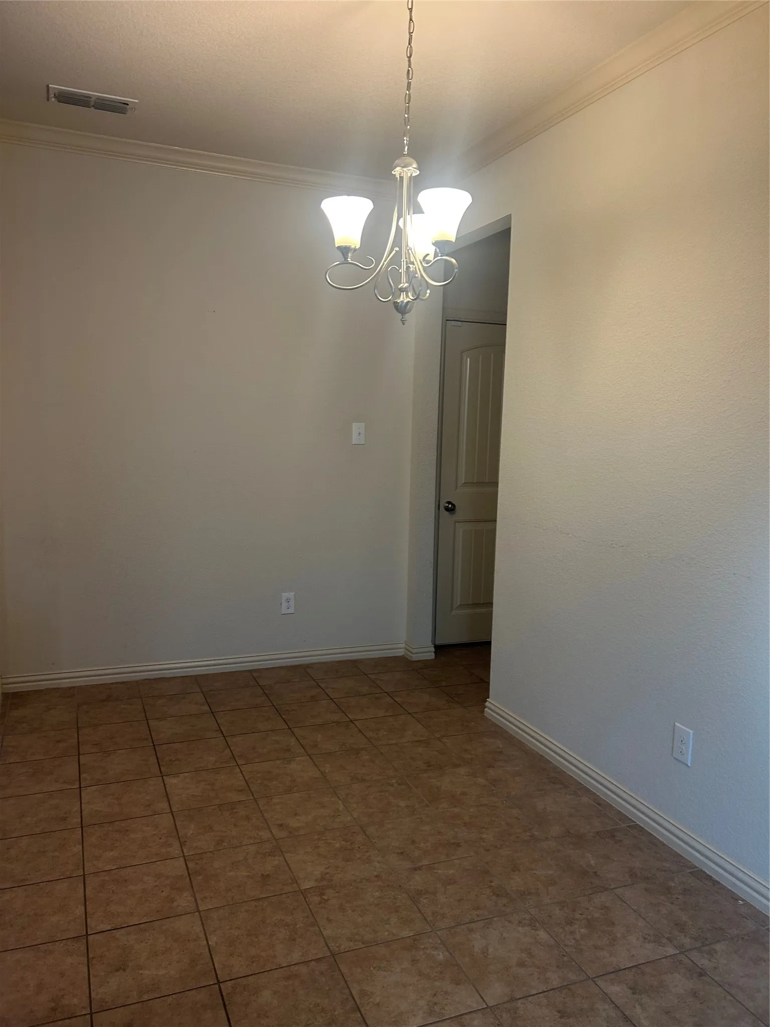 Tile flooring, crown molding, chandelier, white painted walls, and white trim