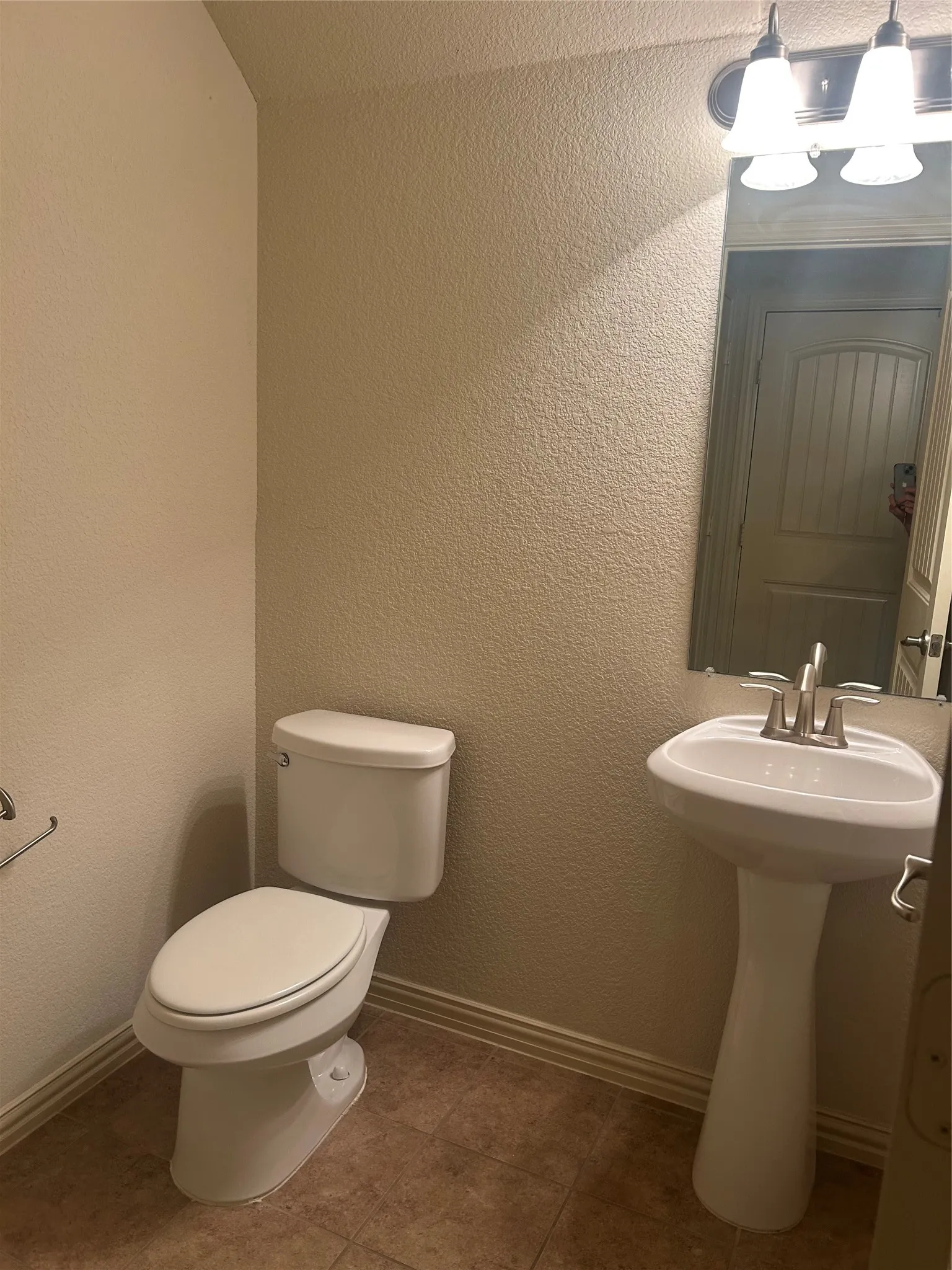 1st Floor -Powder Bath with Pedestal sink with a brushed nickel faucet, ceramic tile flooring, and a wall-mounted light fixture