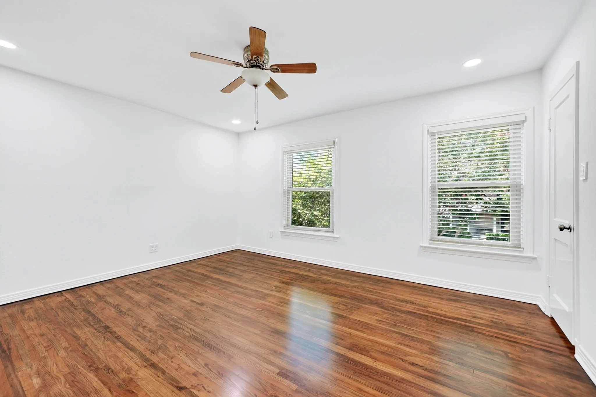 Two windows flood the primary bedroom with natural light.