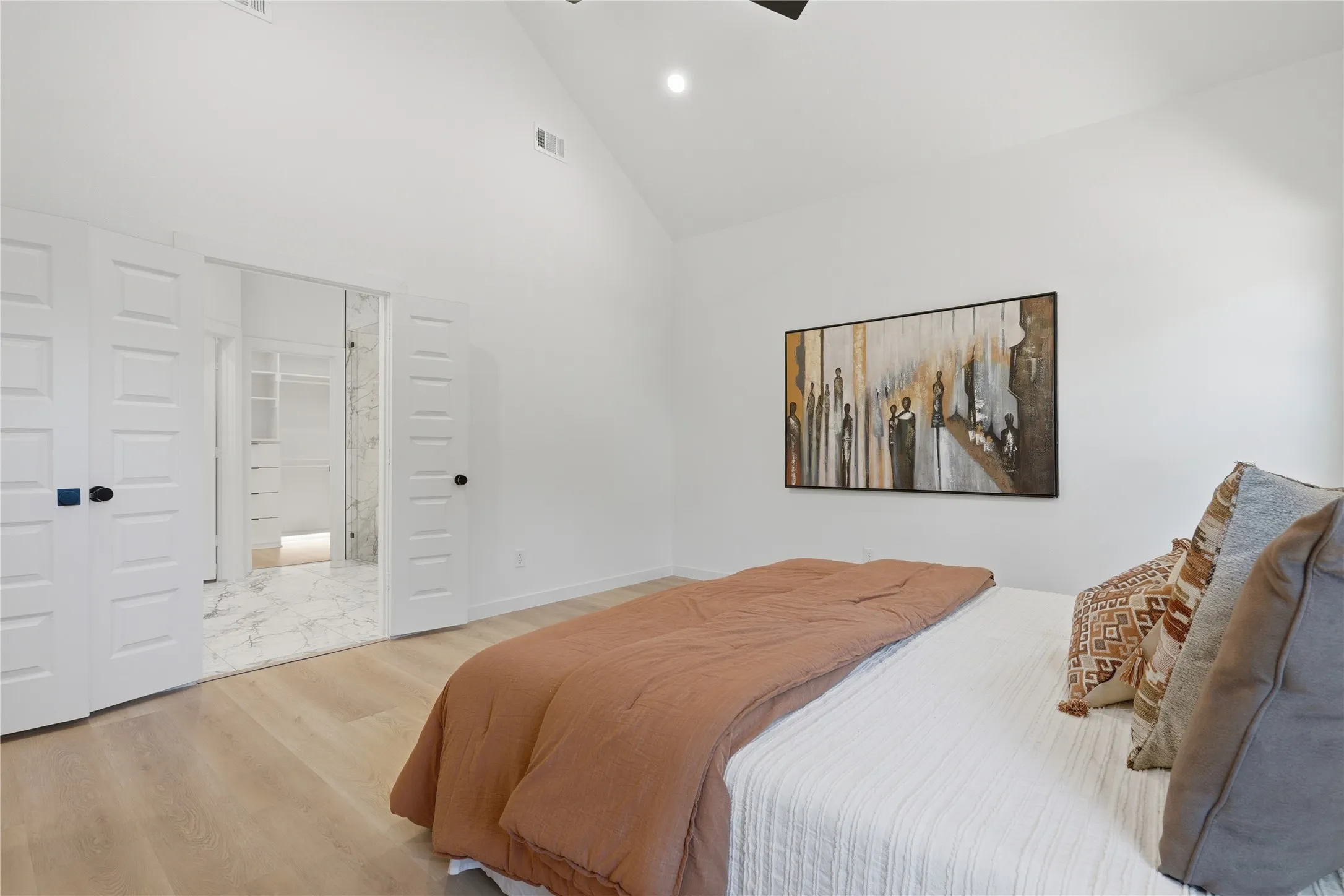 Vaulted ceiling, recessed lighting, double doors, wood-finish flooring, walk-in closet with built-in shelving