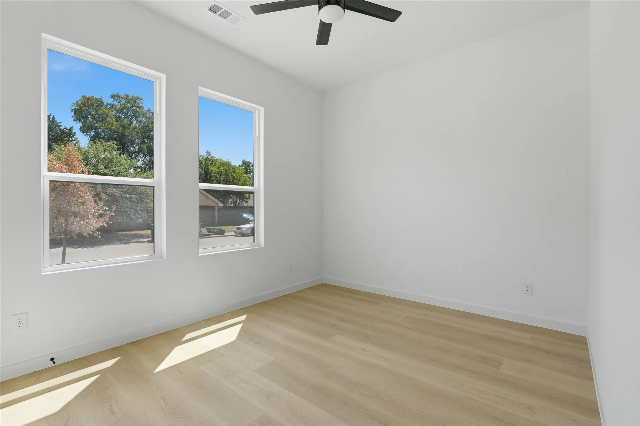 Recessed lighting, wood-finish flooring, two window openings, and a ceiling fan