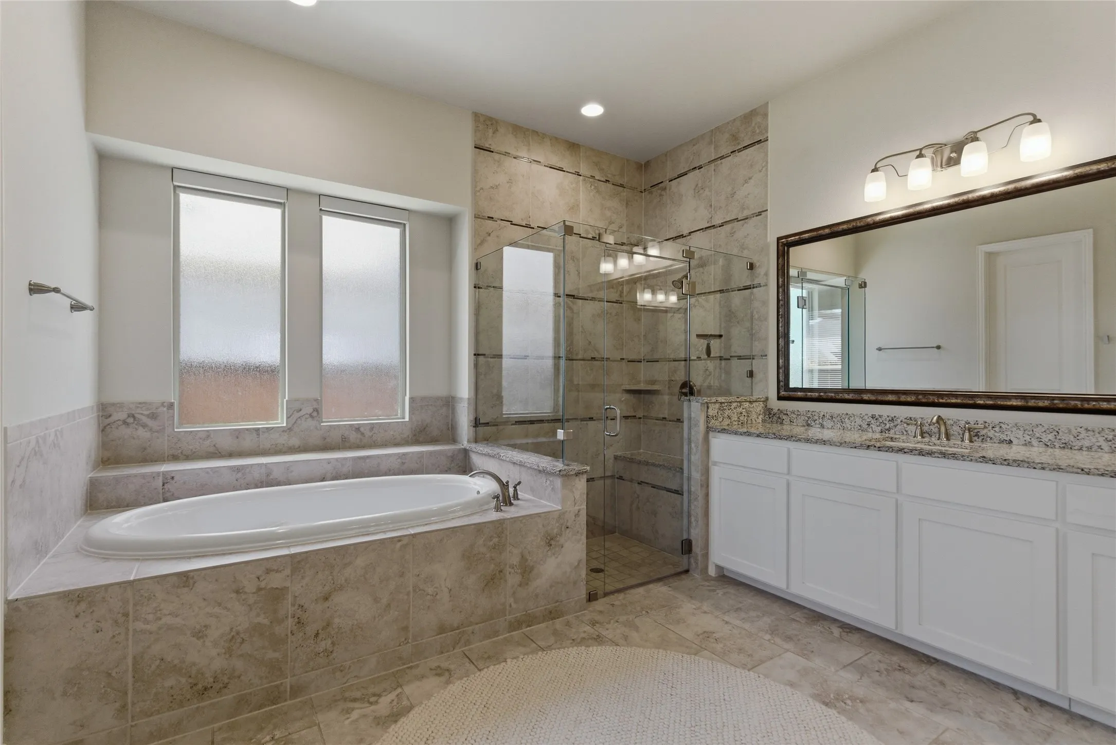 Spacious primary bath with garden tub and separate vanities