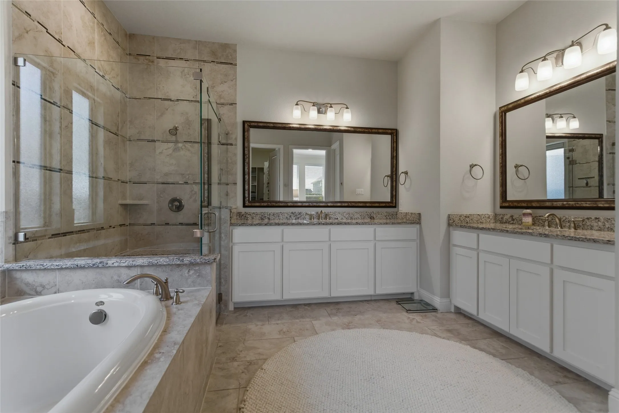Spacious primary bath with garden tub and separate vanities