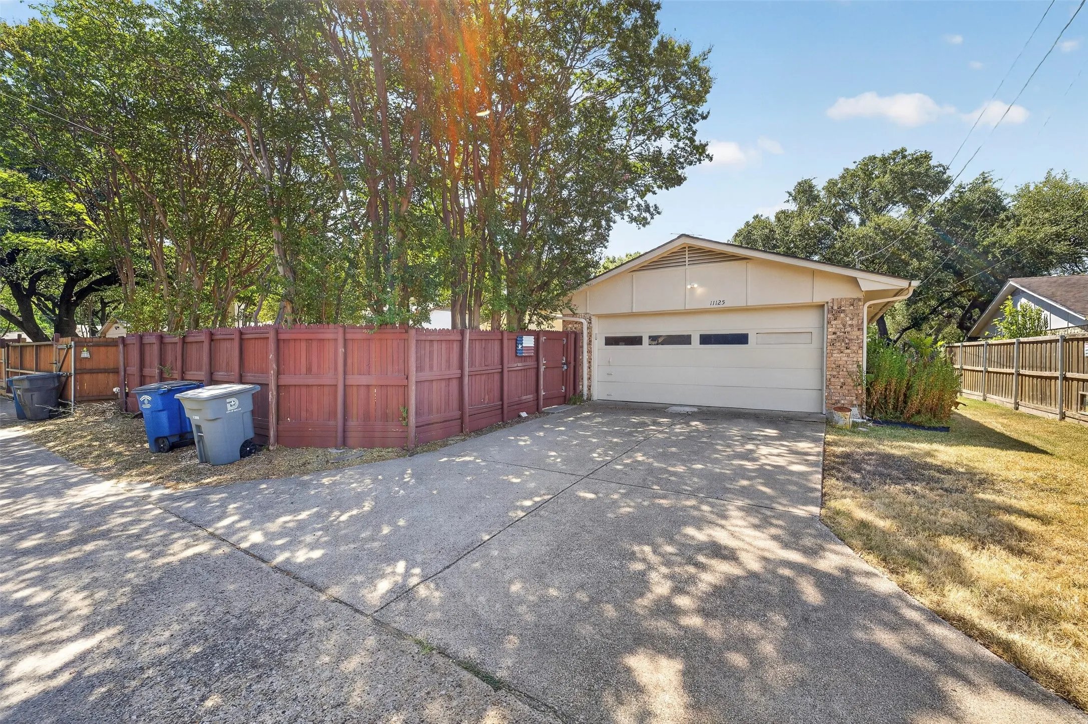 Attached garage with horizontal window panels, brick accent exterior, and a concrete driveway