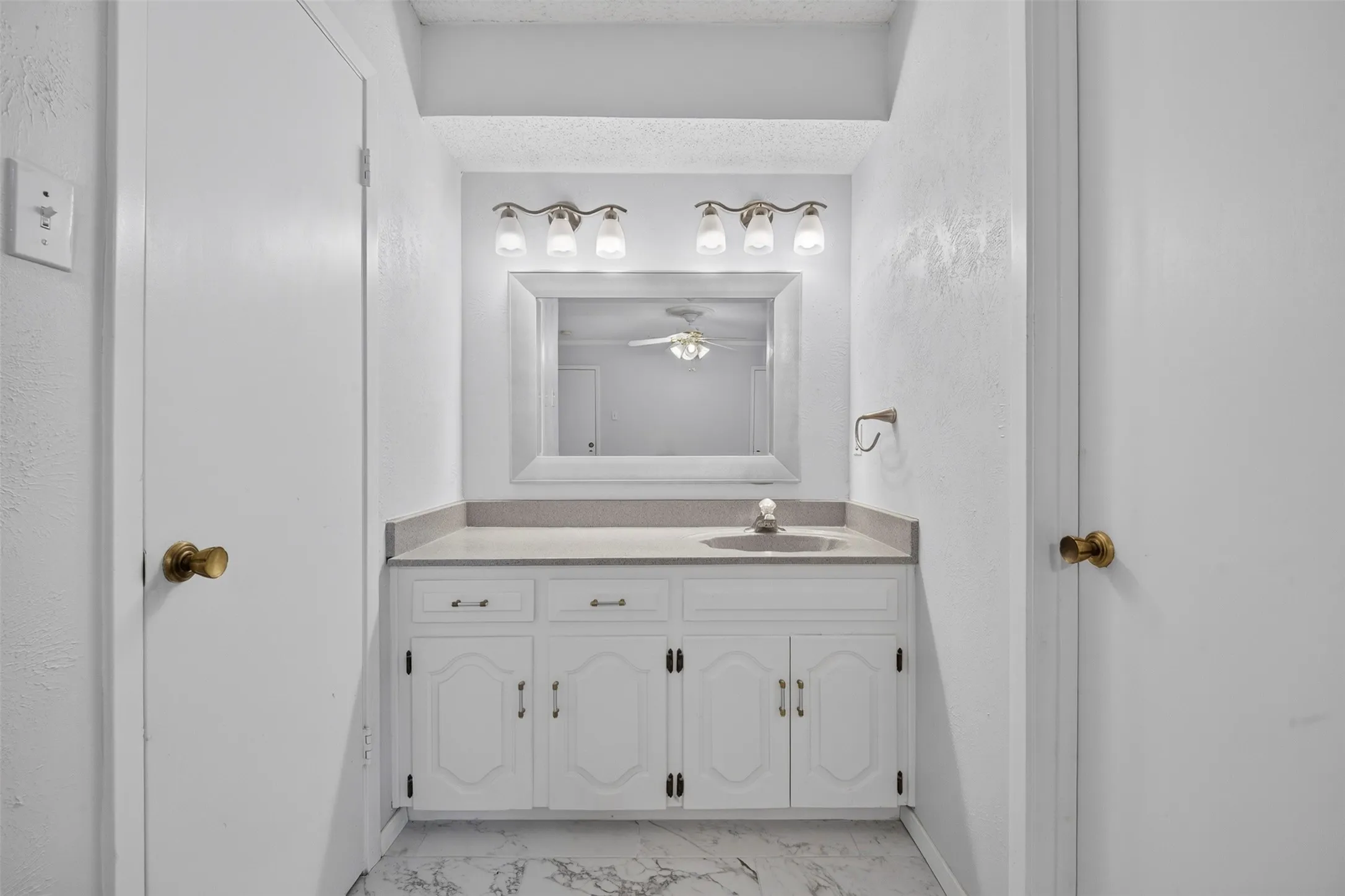 White vanity with cabinet storage and a single basin sink